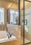 Vertical Bathtub and shower stall of warm toned bathroom with tiled wall and floor