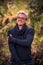 Vertical of a blonde Caucasian in glasses man smiling softly captured on blurred natural background