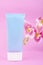 The Vertical of Blue squeeze bottle cosmetic tube and pink color orchid