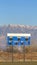 Vertical Blue and white baseball scoreboard above the chain link fence at a sports field