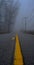 Vertical blurry shot of a road on background of the fog covering the street