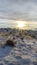 Vertical Bright sun in the cloudy sky over snowy hills and mountain in scenic Utah Valley