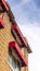 Vertical Building exterior featuring stone brick wall and red awnings on the windows