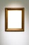 Vertical classic golden picture frame on gray wall