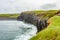 Vertical cliff wall next to a beach on the coastal walk route