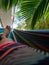 Vertical clodeup of a male foot lying on the Hammock palm leaf background