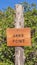 Vertical Close up of an engraved wooden Anns Point sign against green leaves and blue sky