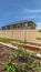 Vertical Close up of growbeds at the sunny backyard of a home with gravel and grasses