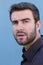 Vertical close up portrait of a young man with a confused, thinking face