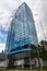 Vertical close-up on a tall building with mirrored windows which reflects a sky with clouds. Business and construction