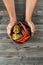 Vertical close up unrecognizable cropped man hands hold fresh green bell pepper vegetable on wood table. Healthy eating