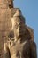 Vertical close up view of ancient statue of egyptian god,with hieroglyphics in the construction located in Luxor temple