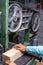 Vertical close-up of a woman carpenter cutting a block of wood with a band saw