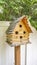 Vertical Close up of wooden birdhouse with several entrance holes at the yard of a home