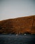 Vertical closeup of a big stone with at the coast with sailing ships