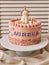 Vertical closeup of a birthday cake with a unicorn on the top and the name Aurelia on it on a plate