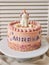 Vertical closeup of a birthday cake with a unicorn on the top and the name Aurelia on it on a plate