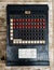 Vertical closeup of a Burrough adding machine on a wooden table captured in top view