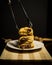 Vertical closeup of chocolate desserts on top of each other with a tong holding one of them