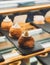 Vertical closeup of choux pastry lined up on the black surface in the bar with blurred background