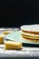 Vertical closeup of a cream cake next to butter pieces