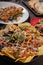 Vertical closeup of delicious nachos with vegetable toppings on a restaurant table