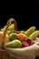 Vertical Closeup detail on a basket full of fruit on a dark background