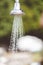 Vertical closeup focus shot of a running pool showerhead outdoors