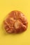 Vertical closeup of fresh-baked bread on a yellow surface