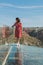 Vertical closeup of a front view of a female on glass bridge enjoying Fraga do Puio Lookout