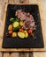 Vertical closeup of grilled meat and vegetables on a nonstick mat on a wooden board