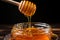 Vertical closeup honey flows from wooden stick to jar, highlighting natural purity