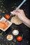 Vertical closeup of a person taking salmon with sticks from a bowl on the table near crackers