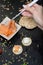 Vertical closeup of a person taking salmon with sticks from a bowl on the table near crackers