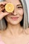 Vertical closeup portrait. Mid aged beautiful Asian woman holding juicy lemon.