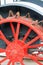 Vertical closeup of red painted antique tractor wheel with steel cleats