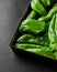 Vertical closeup shot of a box full of green chili peppers also known as Anaheim Pepper