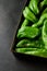 Vertical closeup shot of a box full of green chili peppers also known as Anaheim Pepper