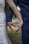 Vertical closeup shot of a bride and a groom forming a heart with their hands