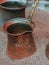 Vertical closeup shot of a coffee maker pot on a sandy surface