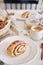 Vertical closeup shot of delicious Nut snails with coffee Cappuccino on the white wood table