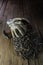 Vertical closeup shot of dirty white gloves, a hammer, and a stack of nails on the wooden ground