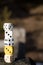 Vertical closeup shot of four white and one yellow dice stacked on each other