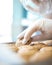 Vertical closeup shot of a gloved hand taking a cookie