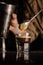 Vertical closeup shot of a person stirring the coffee in a small glass