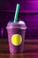 Vertical closeup shot of a purple-colored smoothie in a plastic cup with a blank yellow tag