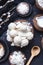 Vertical closeup shot of raw raffaello in a wooden bowl with coconut chunks and a wooden spoon