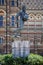 Vertical closeup shot of the sculpture of William Webb Ellis in front of a building on a sunny day