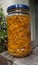 Vertical closeup shot of shredded arnica montana inside a glass jar on a wooden table