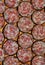 Vertical closeup shot of slices of sausage arranged next to each other